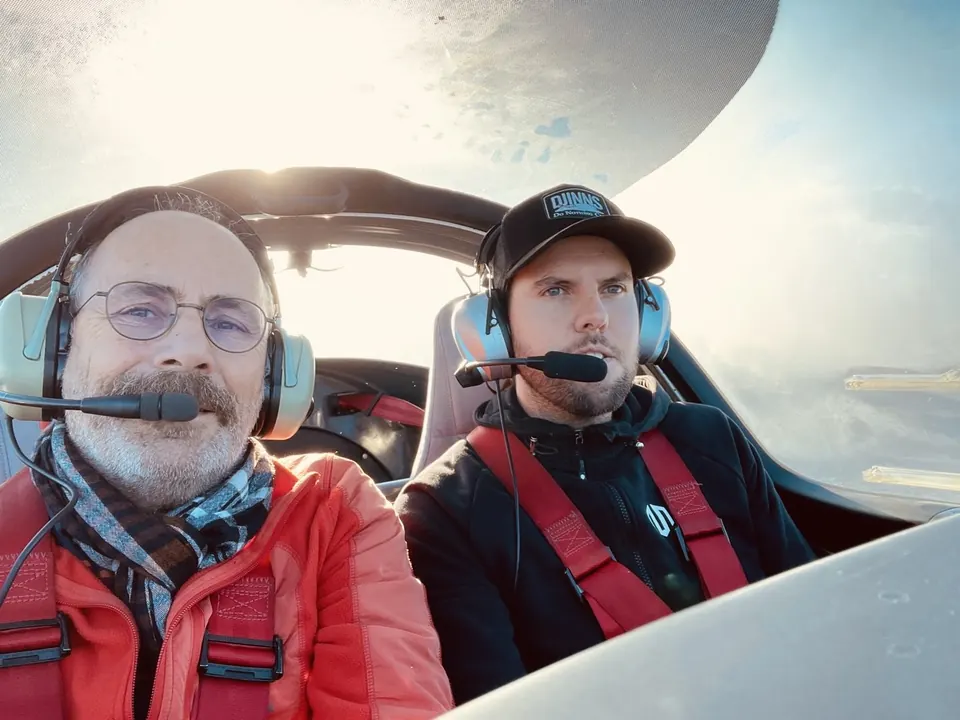 Zwei Piloten mit Headsets nebeneinander im Cockpit der Aquila A210