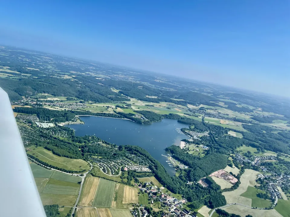 See inmitten von grünen Feldern und Wäldern aus der Luft