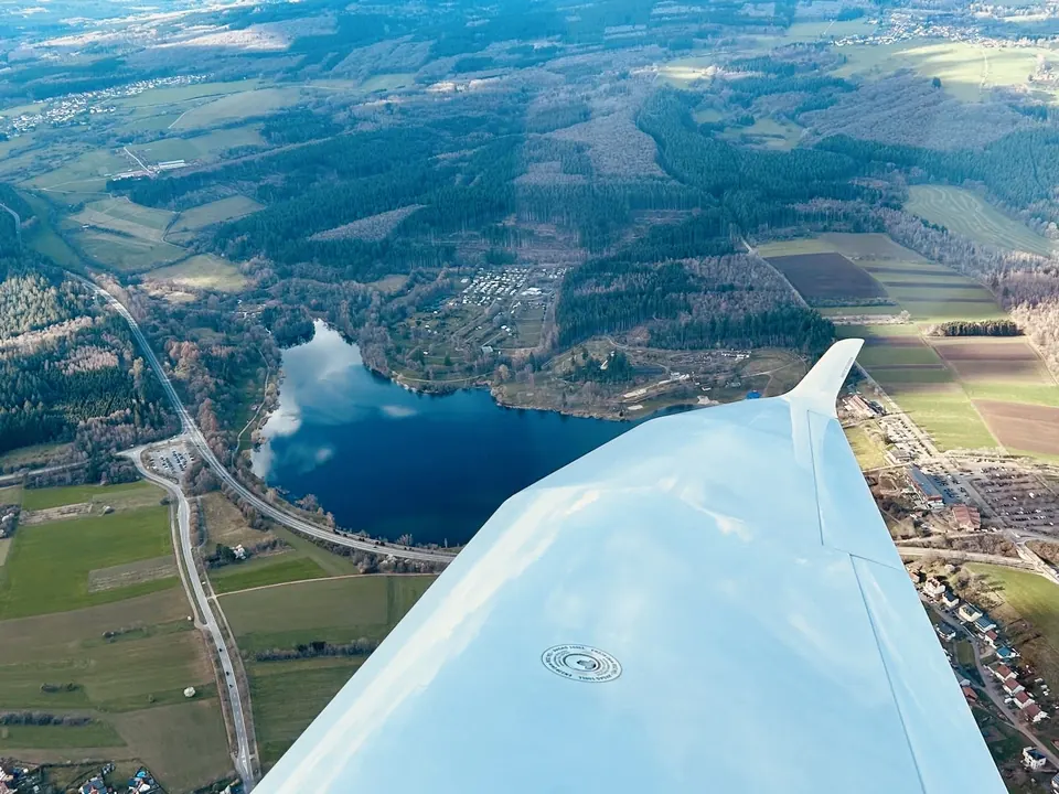Aus dem Cockpit: See und Wälder neben der Tragfläche