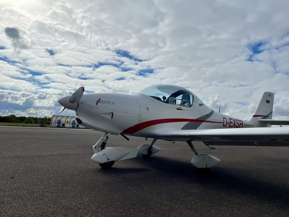 Aquila A210 D-EXSR auf dem Vorfeld unter dramatischem Wolkenhimmel