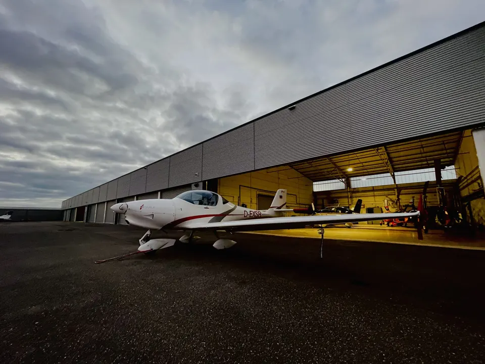 Aquila A210 vor dem Hangar im Abendlicht