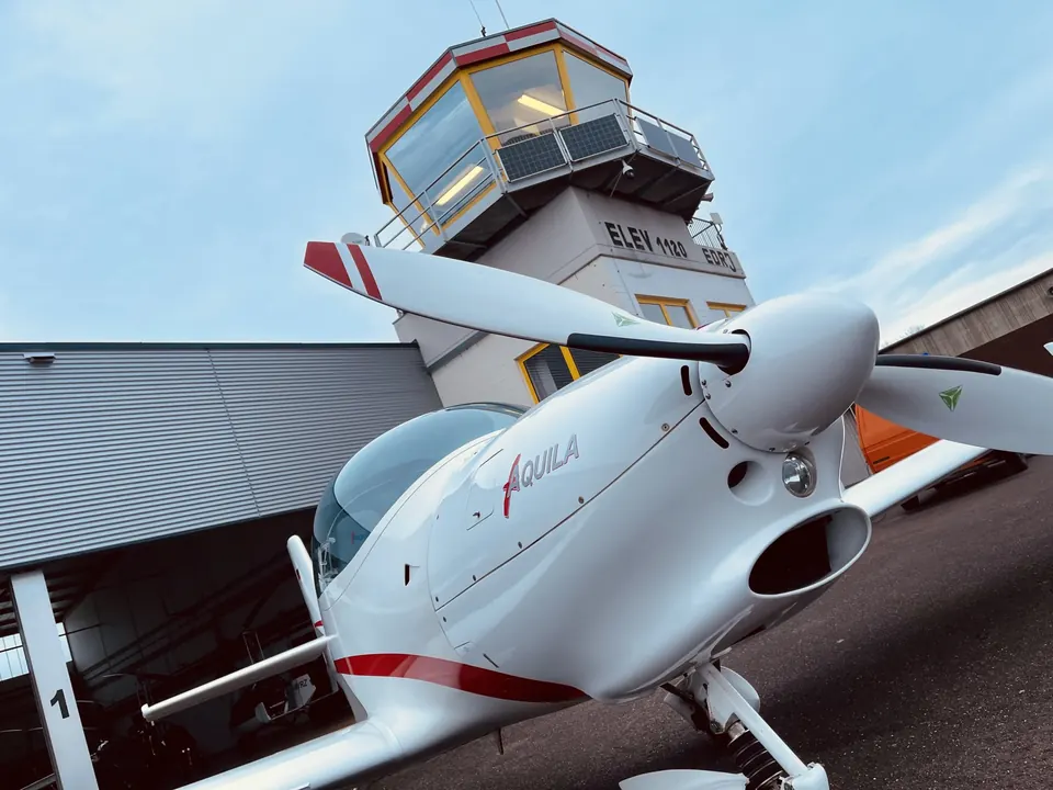 Nase und Propeller der Aquila A210 vor dem Tower in Trier-Föhren