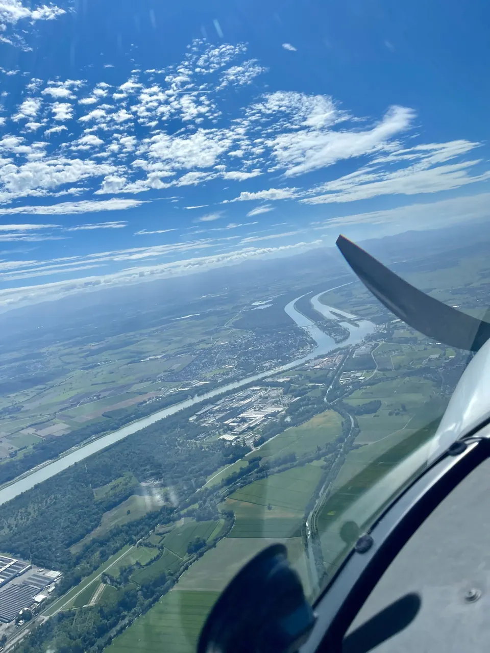 Flusslauf und Felder aus dem Cockpit, Propeller im Bild