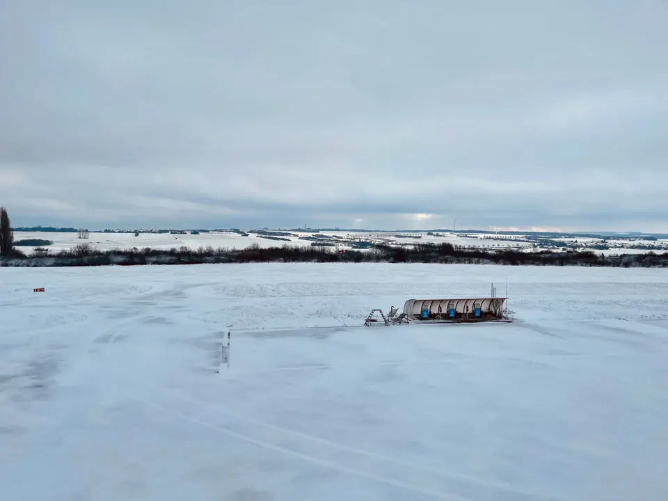 Verschneites Flugfeld mit Hangar am Flugplatz Saarlouis-Düren im Winter