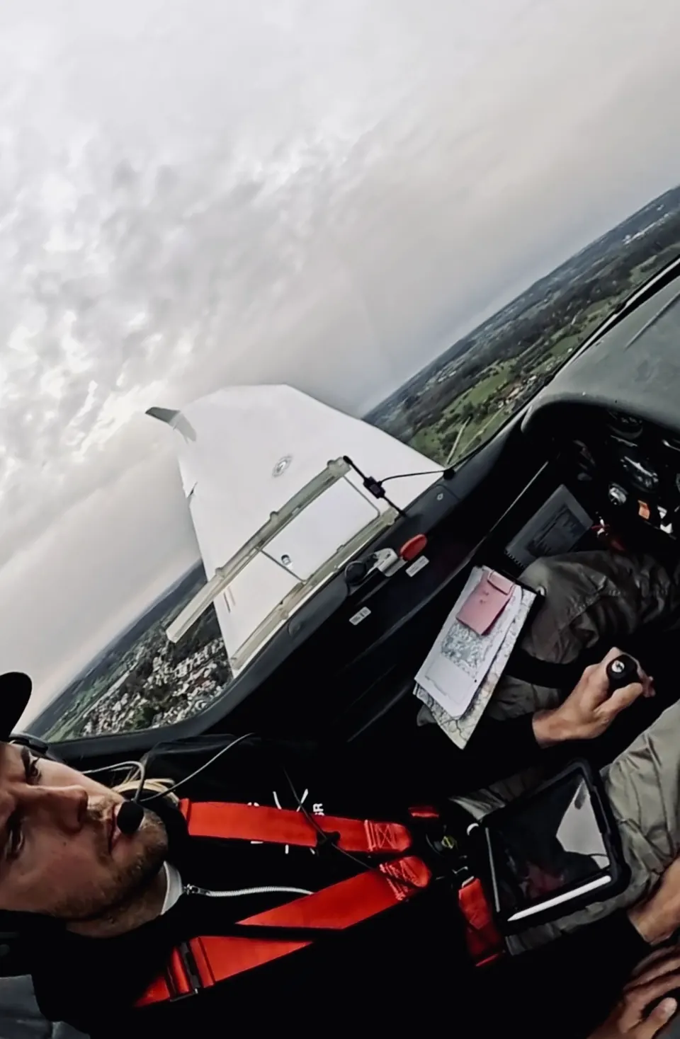 Blick aus dem Cockpit in Querlage über Tragfläche und Wolken beim Flug